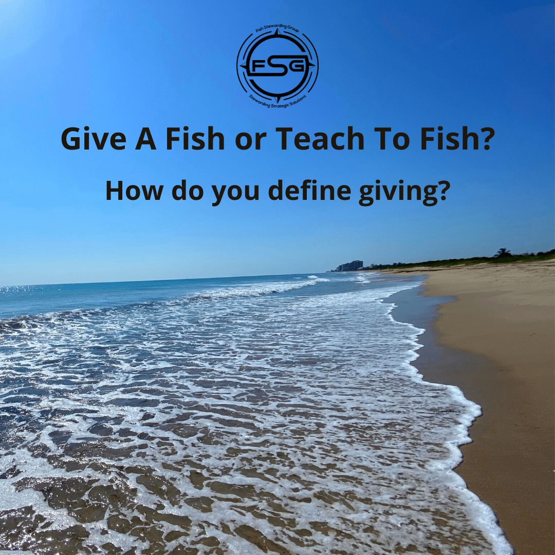 A background of waves coming up on a beach of sand with the sky in the background and no clouds. In Black text, it reads Do you Give a fish or teach to fish? How do you define giving? The FSG logo in black is at the top center of the image. The logo has the letters FSG in the middle with a circle with four pointed arrows facing north, south, east and west with the S connected to that circle. Four rounded lines make the next circle of the circle and the last layer is a thin circle with the text on the Bottom that reads Stewarding Strategist Solutions and on top, the text reads Fish Stewarding Group.