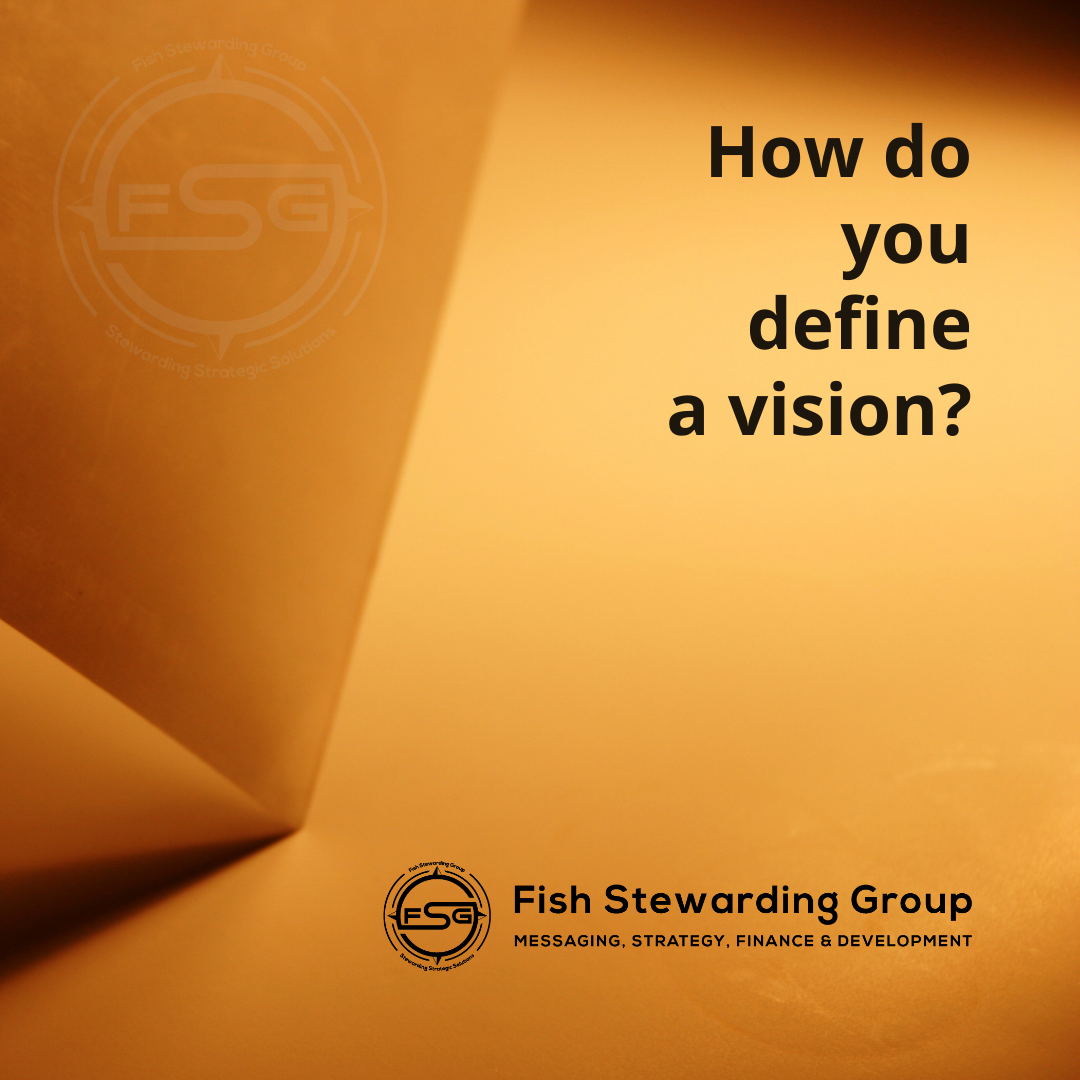 An image of a dark tan background with the edge of paper being folded. There is a little shadow on the edge of the fold. In the upper left corner of the paper is a watermark of the FSG logo in white. To the right in black text, it reads: How do you define a vision. On the lower right side is the FSG logo in black. The logo has the letters FSG in the middle with a circle with four pointed arrows facing north, south, east and west with the S connected to that circle. Four rounded lines make the next circle of the circle and the last layer is a thin circle with the text on the Bottom that reads Stewarding Strategist Solutions and on top, the text reads Fish Stewarding Group. To the right of the logo is the text: Fish Stewarding Group and beneath it are the words Messaging, Strategy, Finance and Development.